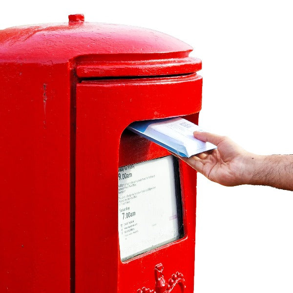 Hand putting package into red Royal Mail postbox